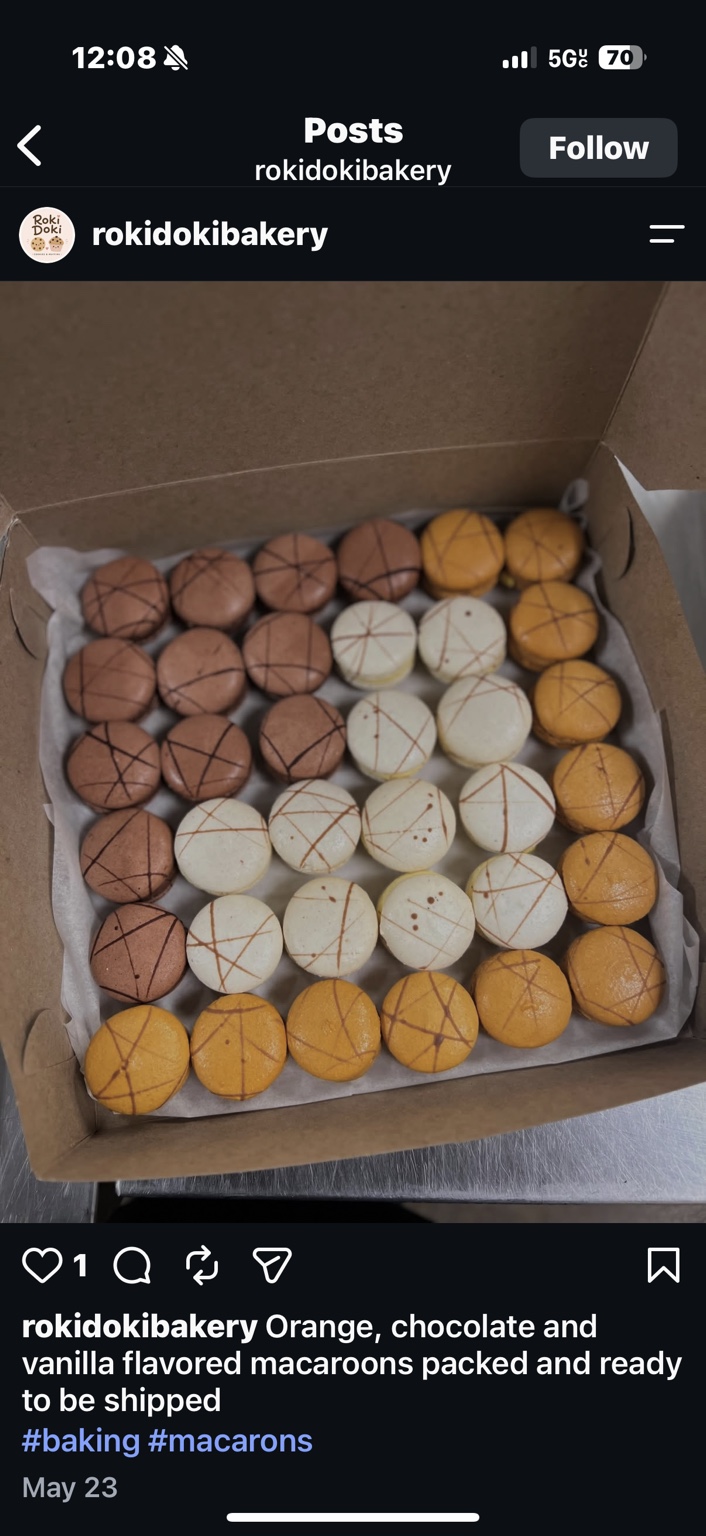 A box of orange, chocolate and vanilla macarons